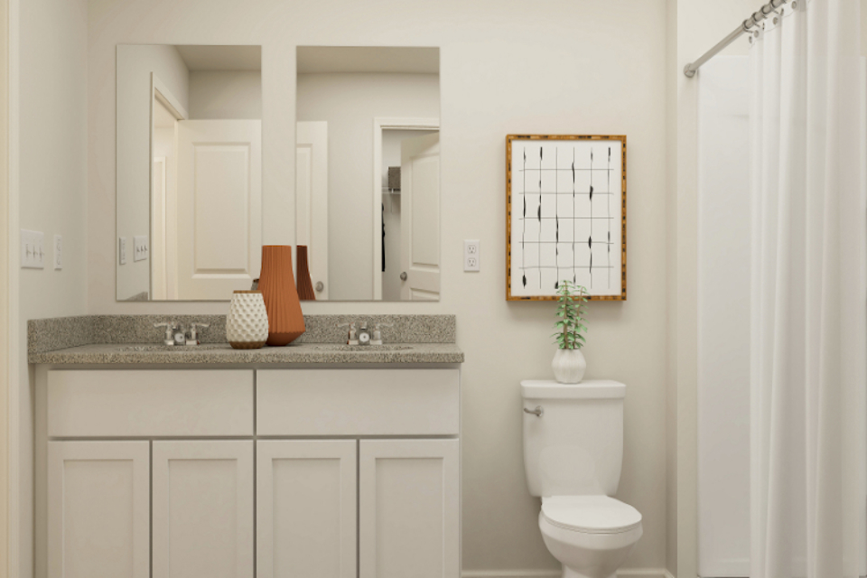 A bathroom with a sink toilet and mirror.