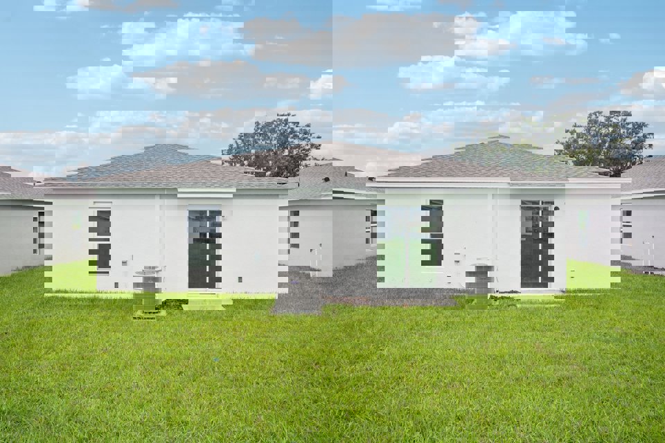 A white house with a green lawn.