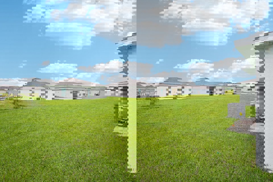 A grassy area with buildings in the background.