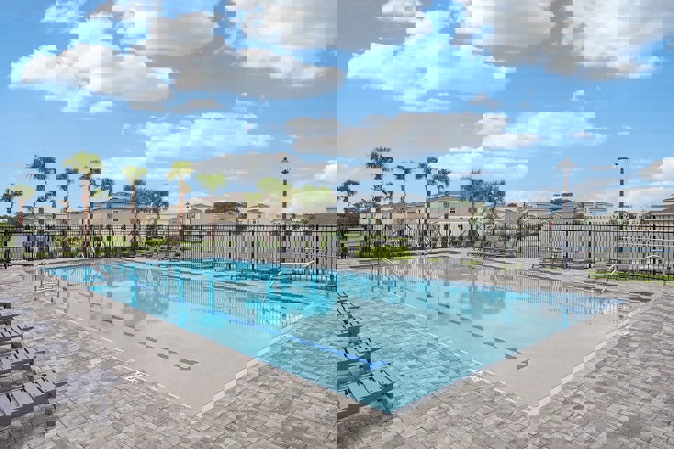 A swimming pool with trees and a fence around it.