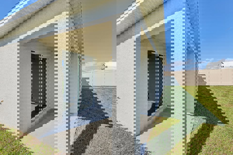 A white building with a grass lawn.