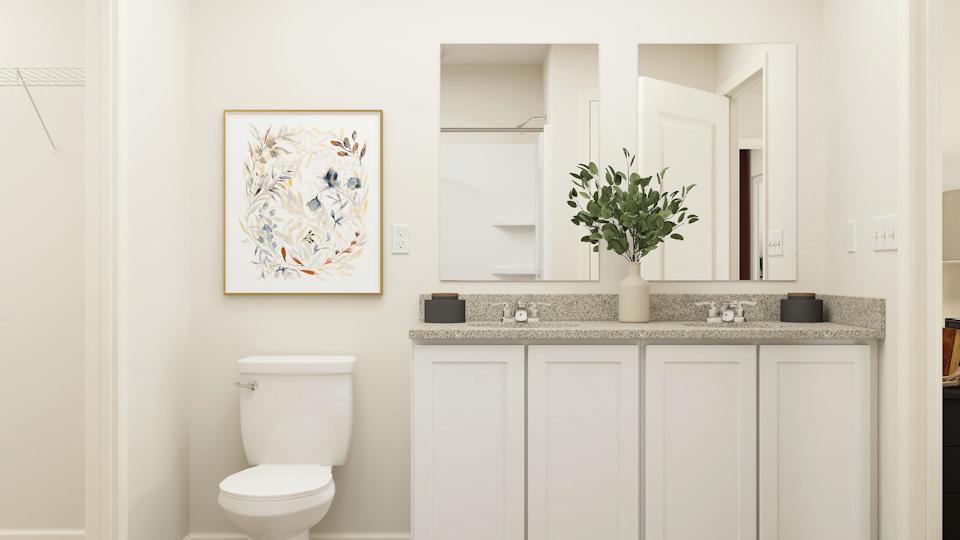 A bathroom with a plant on the counter.