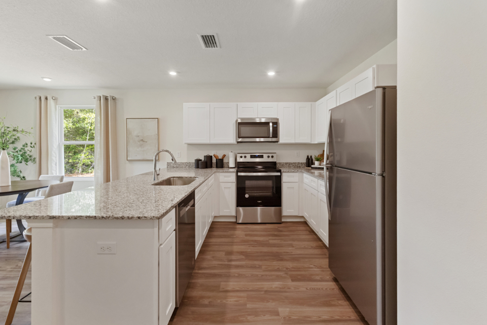 A kitchen with white cabinets.