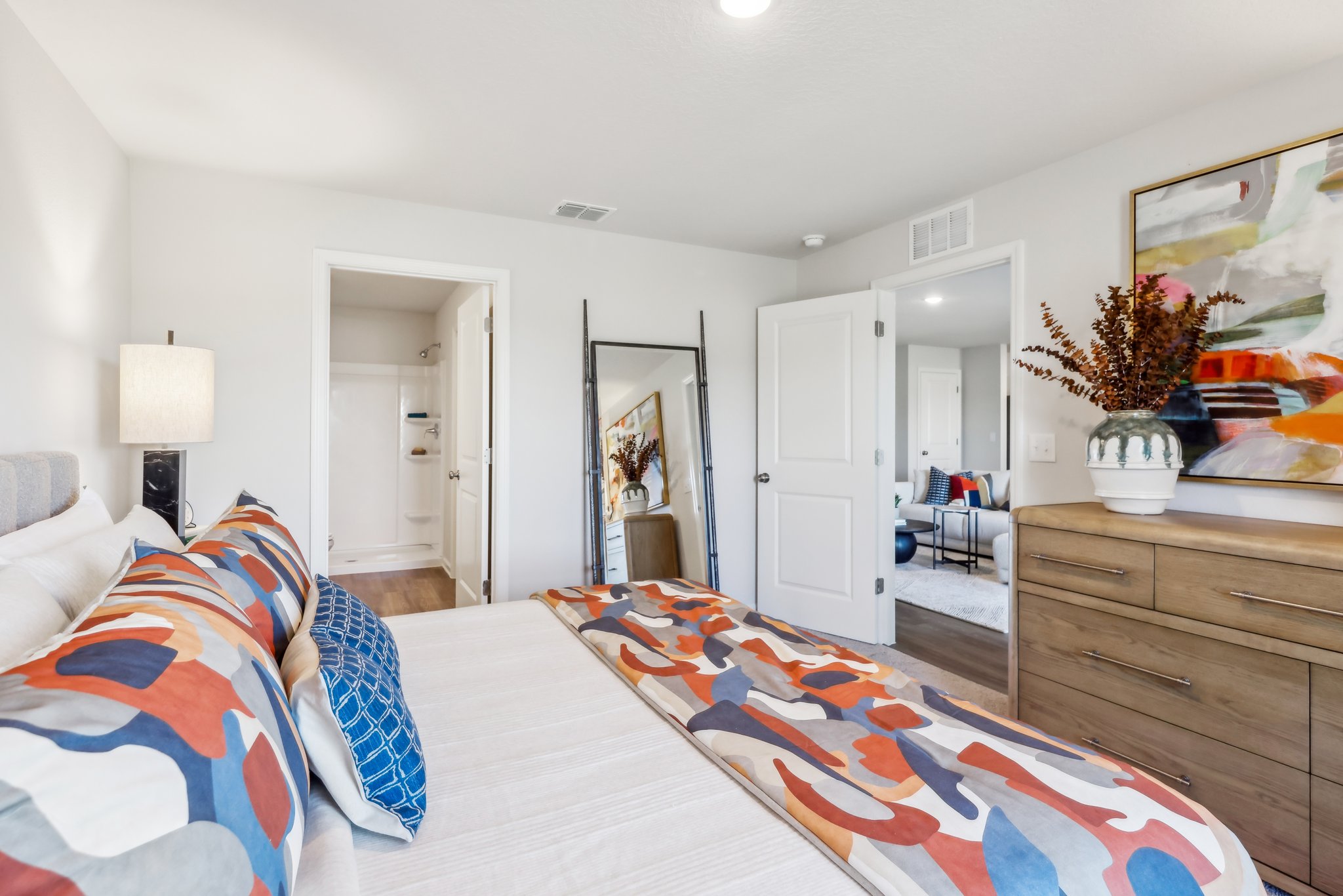 A bedroom with a bed and a dresser.