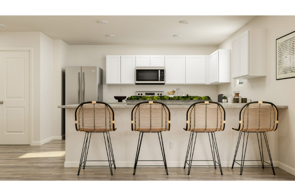 A kitchen with a bar stools and a table.