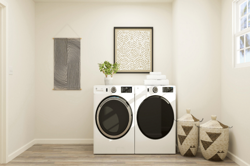 A white laundry room with a black and white washer and dryer.