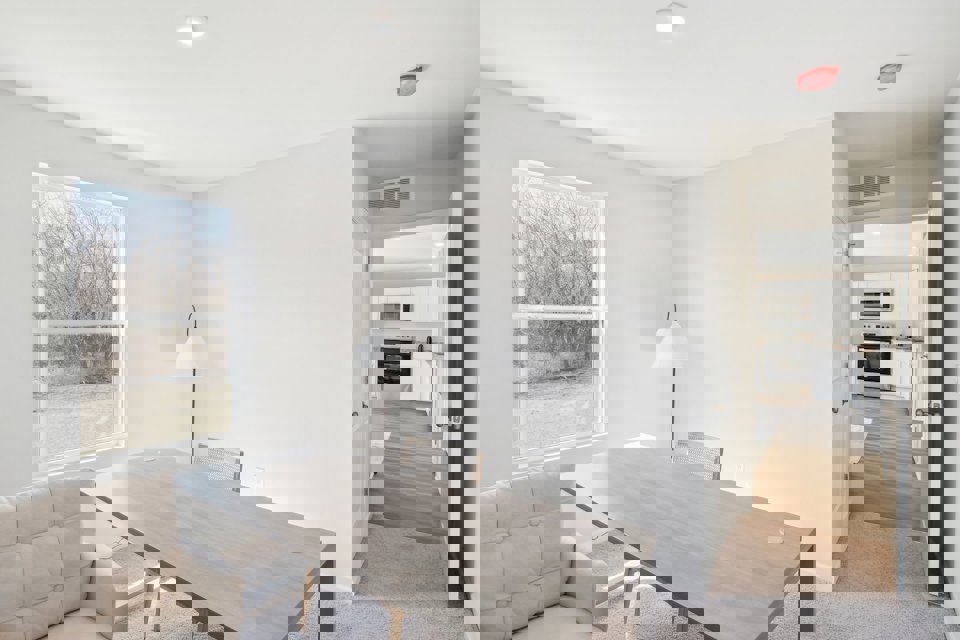 A living room with a table and chairs.