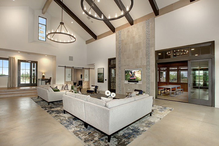 A large living room with a large white couch and a large television.