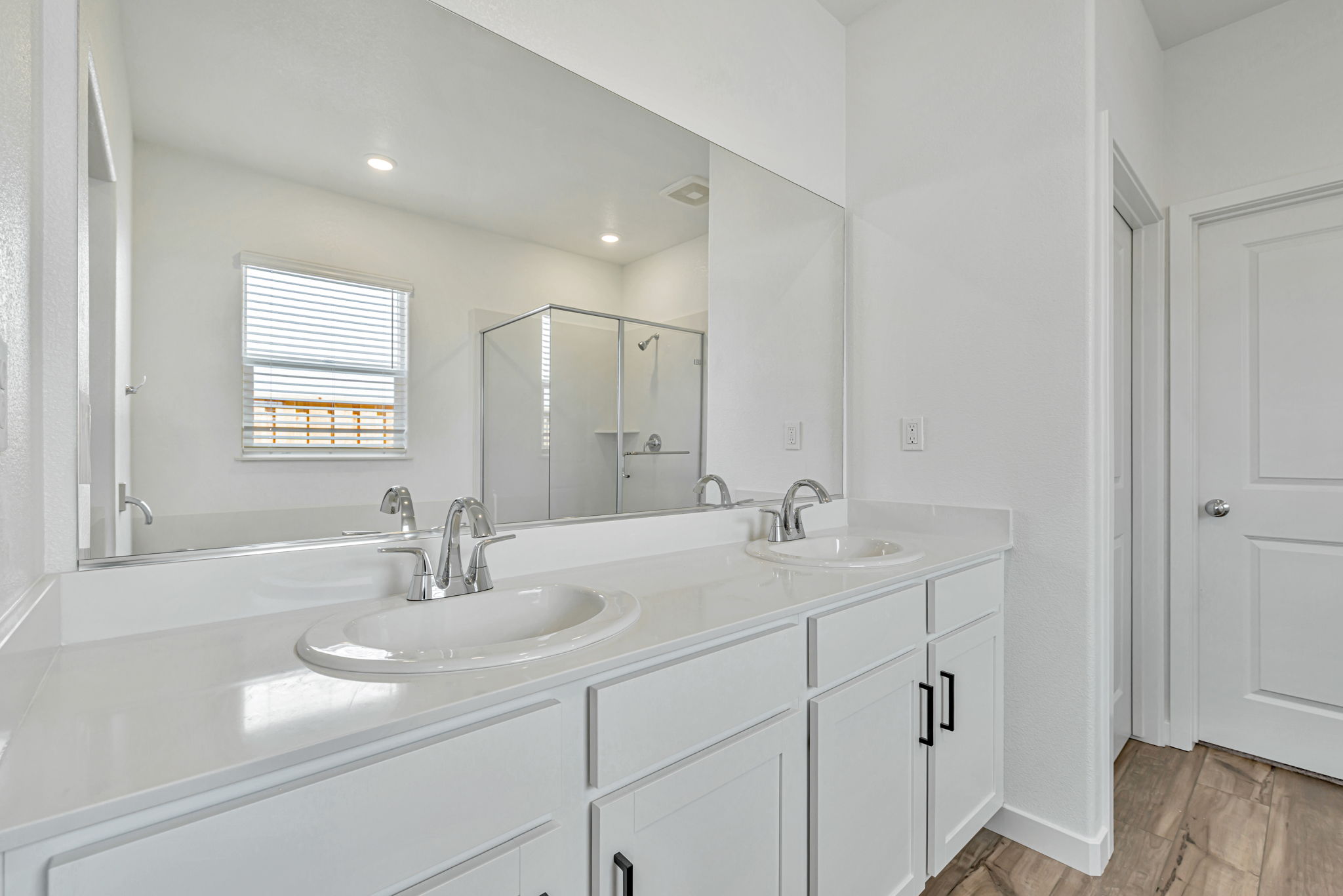 A bathroom with white cabinets.